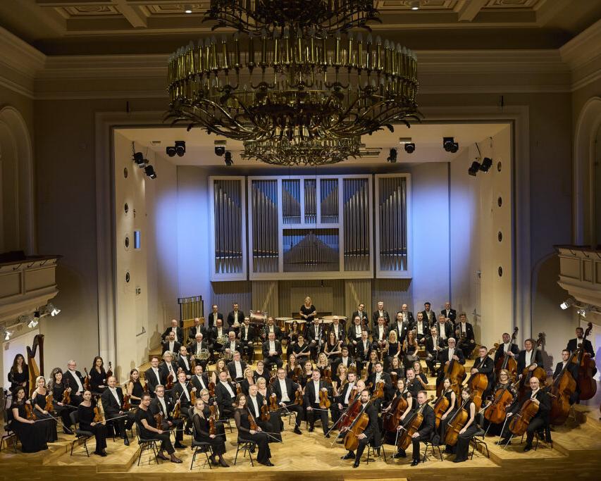Muzyzcy orkiestry siedzą na estradzie