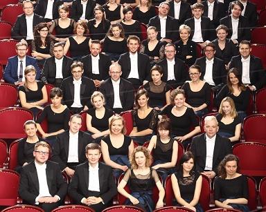 Na widowni w sali koncertwej siedzą muzycy Orkiestry Akademii Beethovenowskiej bez instrumentów w strojach koncertowych - panowie we frakach, panie - w sukniach